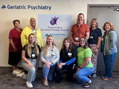 geriatric psychiatry team in front of Dementia Friendly sign